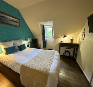 A bed or beds in a room at Logis Hôtel Le Manoir Des Portes