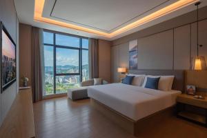 1 dormitorio con cama grande y ventana grande en Atour Hotel Shenzhen Xili Innovation Valley, en Shenzhen