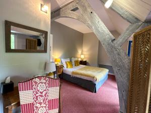 - une chambre avec un lit et une chaise dans l'établissement Logis Hôtel Le Manoir Des Portes, à Lamballe