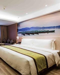 a bedroom with a large bed with a painting on the wall at Atour Hotel Chongqing Jiefangbei in Chongqing