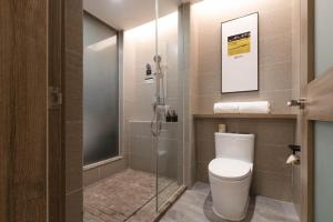 a bathroom with a toilet and a glass shower at Atour Hotel Chongqing Jiefangbei in Chongqing