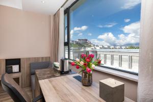 a room with a table with flowers and a large window at Atour Hotel Potala Palace Lhasa in Lhasa