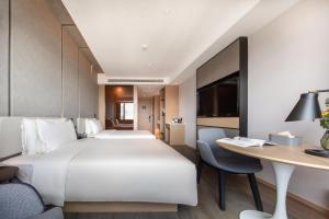 Atour Hotel Kunming West Renmin Road Daguan في كونمينغ: غرفة فندقية بسريرين ومكتب