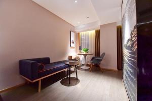 a living room with a blue couch and a table at Atour Hotel Yinchuan Gulou Pedestrian Street in Yinchuan