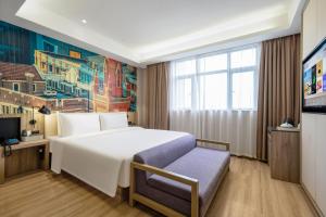 una camera d'albergo con un letto e una TV di Atour Hotel (Shanghai International Tourism and Resorts Zone XiuYan Road) a Shanghai