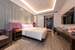 ein Schlafzimmer mit einem großen weißen Bett und einem Sofa in der Unterkunft Atour X Hotel Beijing Sanyuan Bridge in Peking