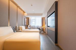 a hotel room with two beds and a flat screen tv at Atour Hotel Shanghai New International Expo Center South Yanggao Road in Shanghai