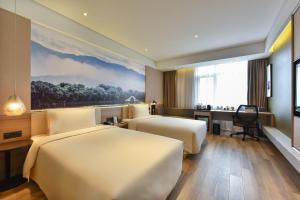 een hotelkamer met 2 bedden en een bureau bij Atour Hotel Zhongguancun Yongfeng Base Beijing in Beijing