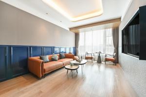 uma sala de estar com um sofá e uma mesa em Atour Hotel Beijing Hepingli UIBE em Pequim