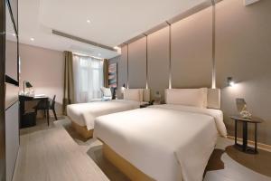 a hotel room with two beds and a desk at Atour Hotel Beijing Guomao Panjia Yuan in Beijing