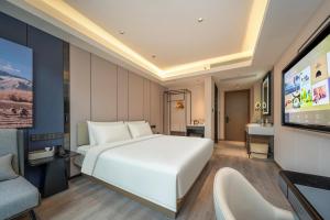 a bedroom with a large white bed and a flat screen tv at Atour Hotel Shanghai Hongqiao Xinzhuang Business District in Shanghai