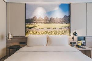 ein Schlafzimmer mit einem Bett und einem Bild der Berge in der Unterkunft Atour Hotel Guiyang Century City Shopping Center in Guiyang