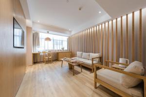 a living room with a couch and a table at Atour X Hotel Wuxi New Zone Gelunbu Plaza in Wuxi