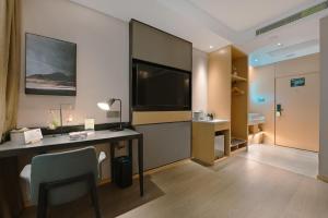 a hotel room with a desk and a television at Atour Hotel Beijing Guomao Panjia Yuan in Beijing