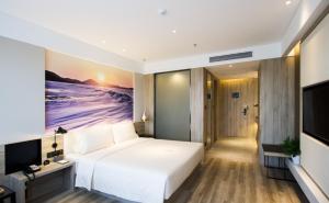 um quarto com uma grande cama branca e uma televisão em Atour Hotel Shenyang Hunnan Olympic Sports Center em Shenyang
