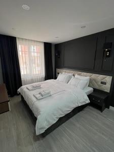 ein Schlafzimmer mit einem großen Bett mit weißer Bettwäsche in der Unterkunft Cosy suites hotel in Antalya