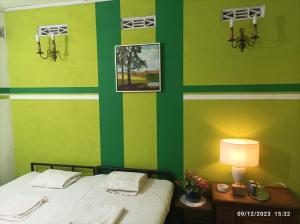 a bedroom with green and yellow walls and a bed at Farmhouse in Jaffna District 