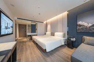 a hotel room with a bed and a flat screen tv at Atour Hotel Shanghai Zhangjiang Park Science City in Shanghai