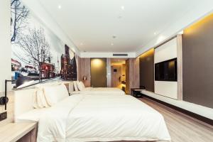 a bedroom with two large beds and a tv at Atour Hotel Shanghai Pudong Airport in Shanghai