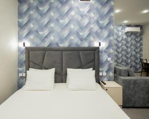 a bedroom with a large bed and a chair at "Rush Hotel" in Astana