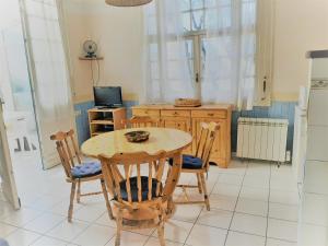 kuchnia ze stołem, krzesłami i telewizorem w obiekcie Appartement cosy 4 pers, proche plage et commerces, Capbreton - FR-1-239-887 w mieście Capbreton