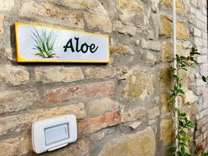 een bord op een stenen muur met een aloë bord bij Assisi, Angolo di Matilde in Petrignano