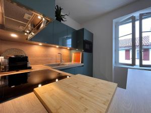 une cuisine avec une table en bois et un évier dans l'établissement Appartement lumineux 3 pièces près des Halles et de la plage, wifi, clim, parkings proches - FR-1-239-910, à Saint-Jean-de-Luz