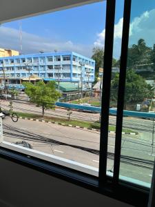 een raam met uitzicht op een gebouw bij NADPOB Station นัดพบสเตชั่น in Ban Tha Kham