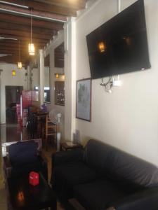 a living room with a couch and a flat screen tv at Birds Nest 2.0 in Kampot