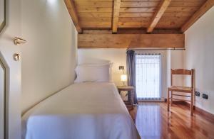 ein Schlafzimmer mit einem Bett, einem Stuhl und einem Fenster in der Unterkunft Balcony Lake View Apartment in Lierna