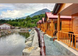 The Shivalaya Retreat - A River Side Resort في Jagatsukh: صف من المباني الخشبية بجانب النهر