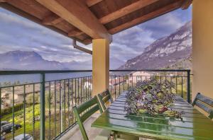 einen Tisch auf dem Balkon mit Bergblick in der Unterkunft Balcony Lake View Apartment in Lierna