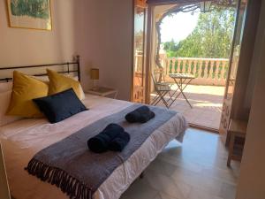 ミハスにあるCasa Hermosa Mijasのベッドルーム1室(ベッド1台、帽子2つ付)