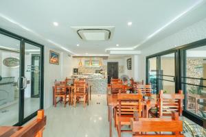 un restaurante con mesas y sillas de madera y una barra en Porpiang Hotel - โรงแรมพอเพียง en Nakhon Phanom