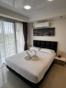 a bedroom with a large bed with two rings on it at Cozy apartment near the sea in Mai Khao in Ban Bo Sai Klang
