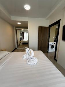 una camera con un letto e un asciugamano sopra di Cozy apartment near the sea in Mai Khao a Ban Bo Sai Klang