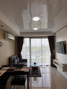 un soggiorno con divano e una grande finestra di Cozy apartment near the sea in Mai Khao a Ban Bo Sai Klang