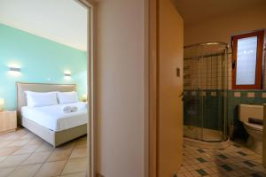 a bedroom with a bed and a bathroom with a shower at Mani Tower Villa in Akrogiali +86 photos