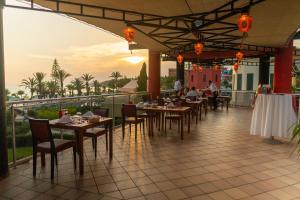 a restaurant with tables and chairs on a balcony at AQI Pegasos Royal in Avsallar