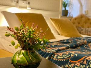 a vase with flowers on a table next to a bed at Hotell St Clemens in Visby