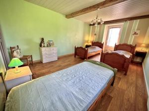 1 dormitorio con cama, sillas y ventana en Chez marie, en Asson