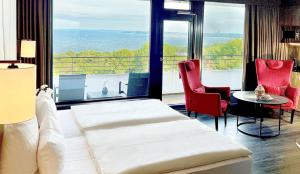 a hotel room with a bed and a view of the ocean at PLAZA Premium Timmendorfer Strand in Timmendorfer Strand