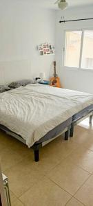 un grande letto in una camera da letto con chitarra di Casa Rambla - Restore - Relax a Bédar