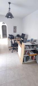 un ufficio con scrivania, computer e sedie di Casa Rambla - Restore - Relax a Bédar