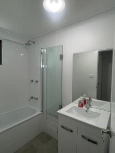 a white bathroom with a sink and a shower at YnY Guest house in Waterford