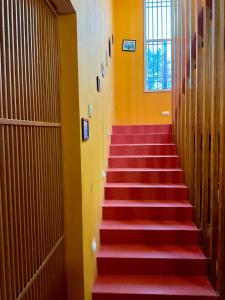 una escalera con escalones rojos en un edificio de oficinas en Zorba the Buddha, en Begusarai