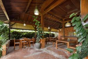 a restaurant with wooden ceilings and tables and chairs at Canggu Bona Kubu in Canggu