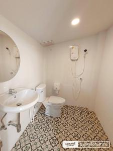 y baño con aseo blanco y lavamanos. en บ้านสุขใจ อัมพวา en Samut Songkhram