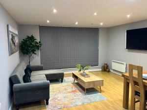 a living room with a couch and a table at Newly Refurbished One Bedroom Apartment Swindon in Swindon