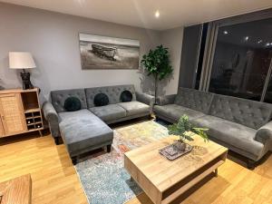 a living room with a couch and a coffee table at Newly Refurbished One Bedroom Apartment Swindon in Swindon